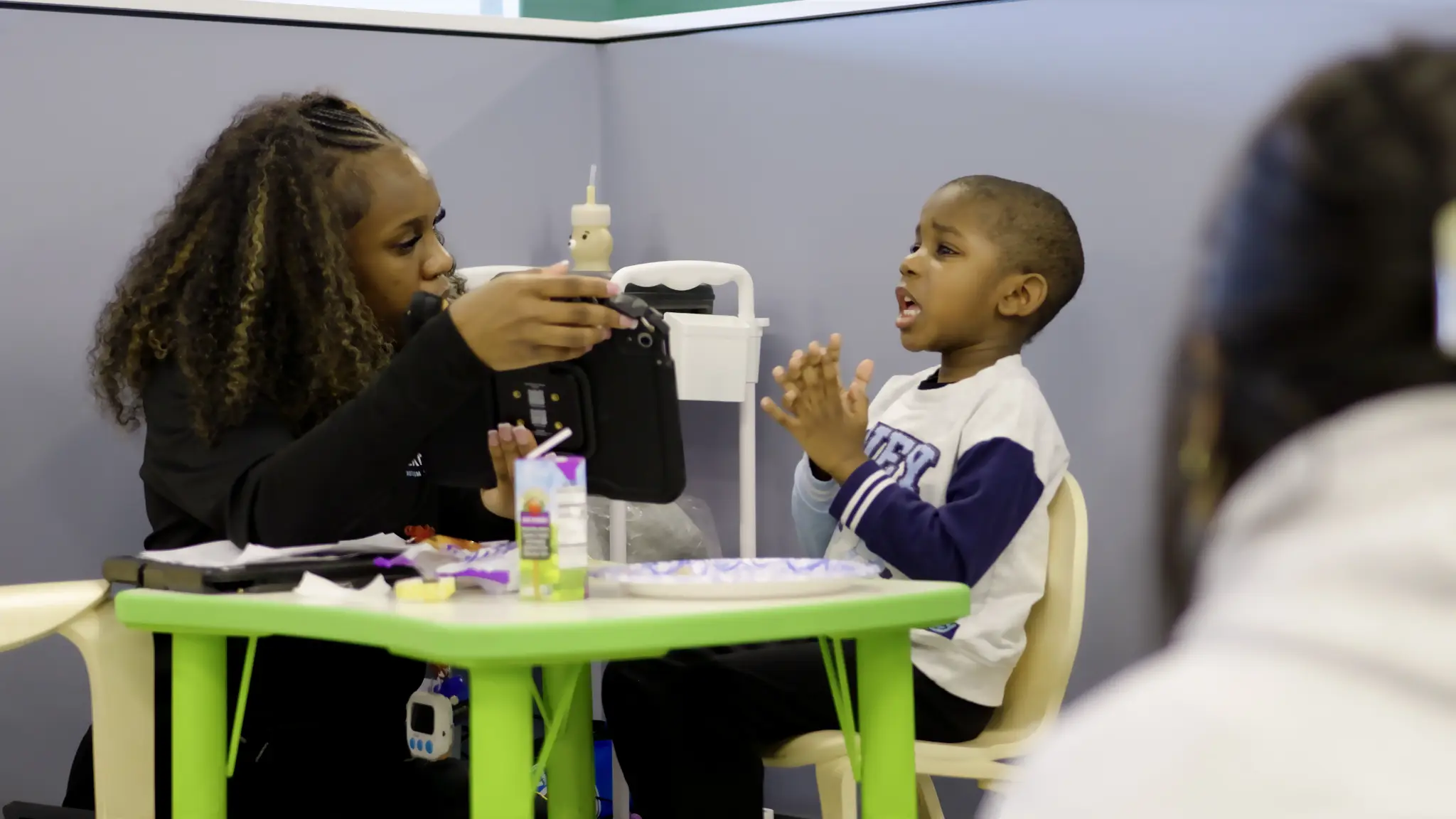 Bierman clinician using a tablet during a child-focused assessment activity